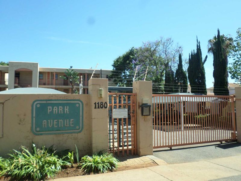Front entrance view of Park Avenue apartment complex featuring a secure gated access point with electric fencing and perimeter walling.