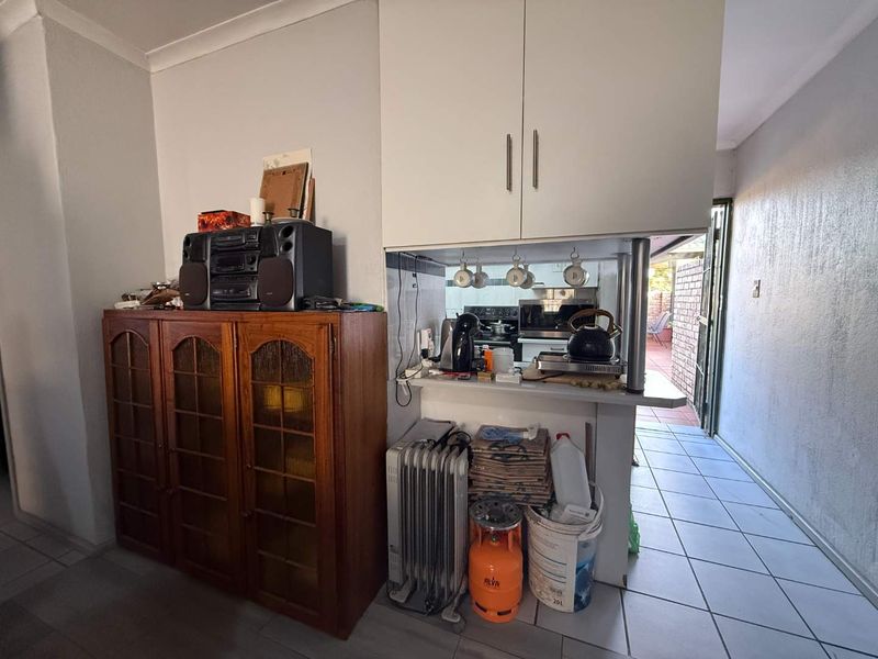 A compact kitchen area featuring built-in cabinetry and a breakfast counter, with direct access to an outdoor patio area.