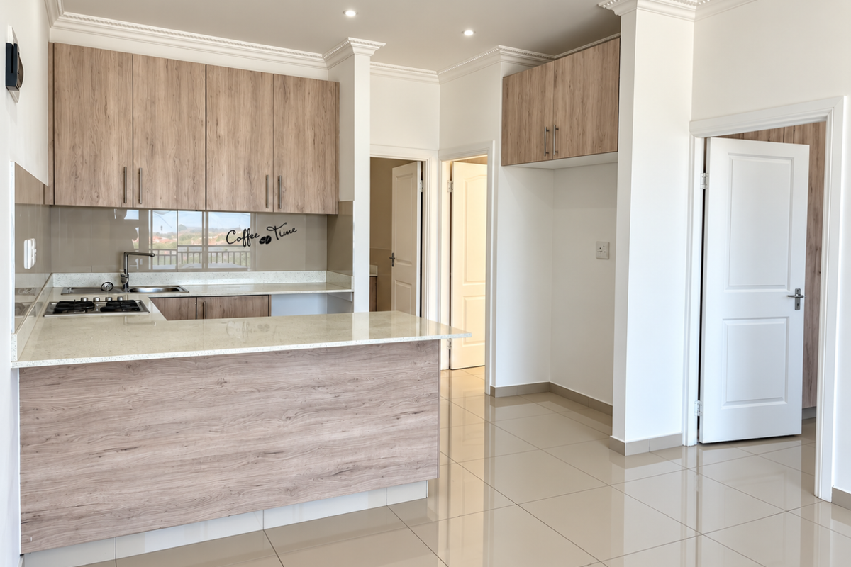Modern kitchen featuring light wood-grain cabinetry, stone countertops, gas hob, and sleek tiled flooring in an open-plan layout.