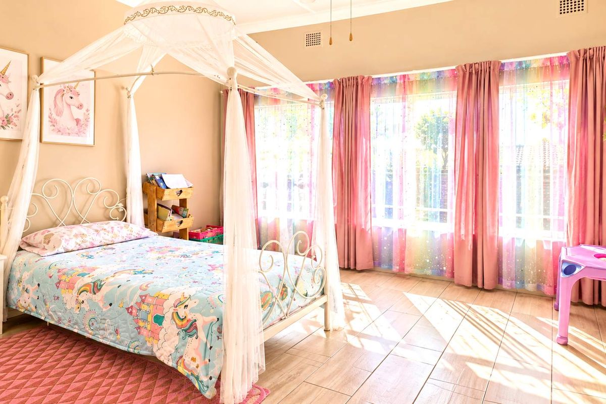 A bright and well-maintained bedroom featuring tiled flooring and large windows with natural light.