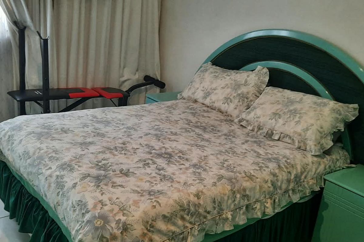 A bedroom featuring tiled flooring and a built-in headboard structure.
