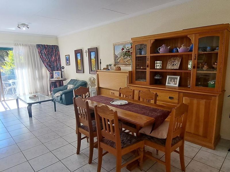 Open-plan living and dining area featuring tiled flooring and a sliding glass door providing access to an outdoor patio space.