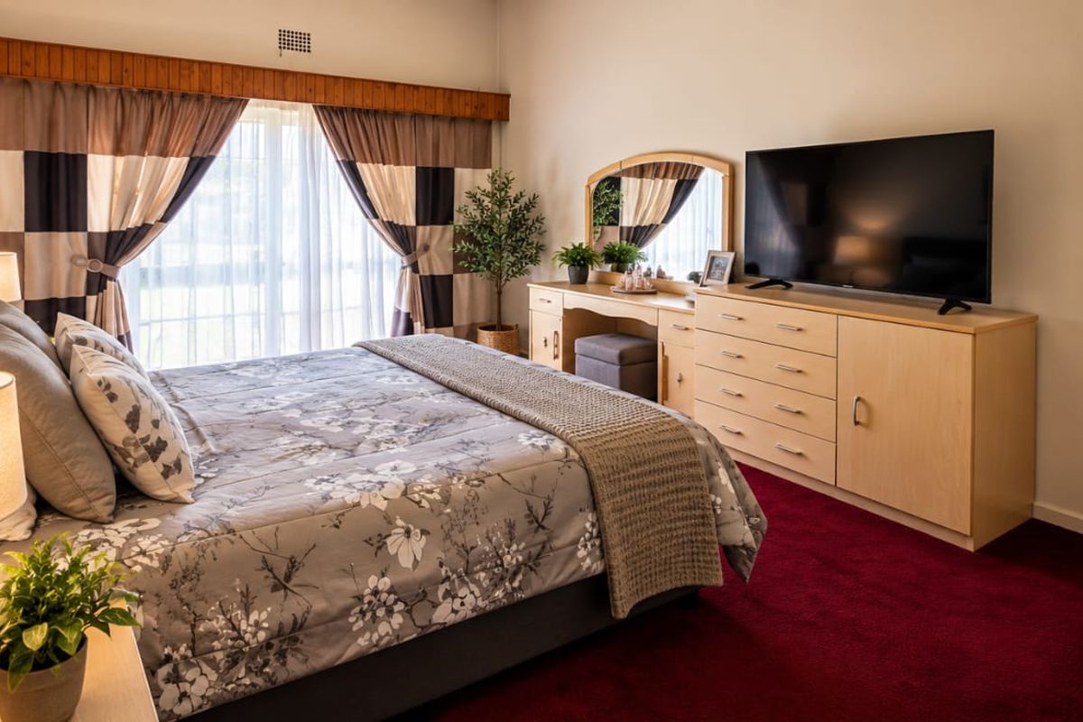 A well-maintained bedroom featuring carpeted flooring, a built-in wardrobe, and sliding glass doors that provide natural light.