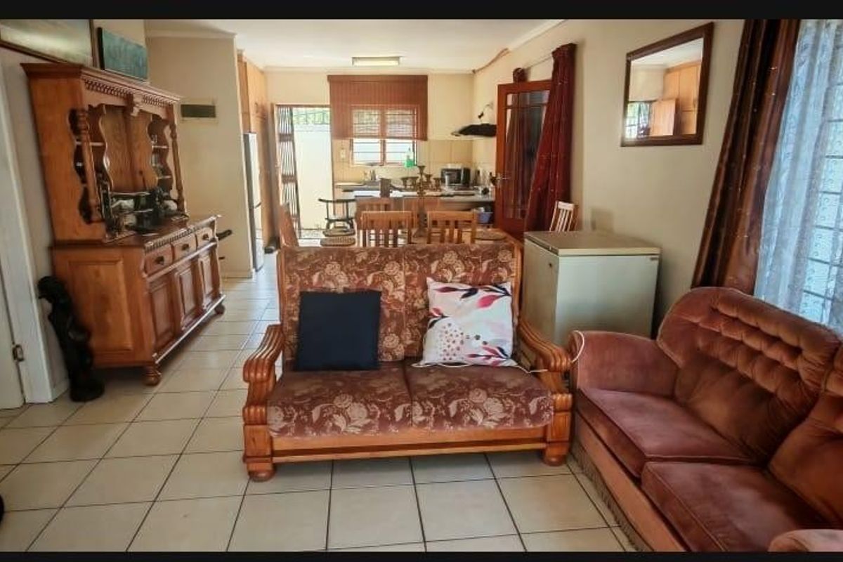 Open-plan living and kitchen area featuring tiled flooring and functional cabinetry, offering a versatile space for daily living and dining.