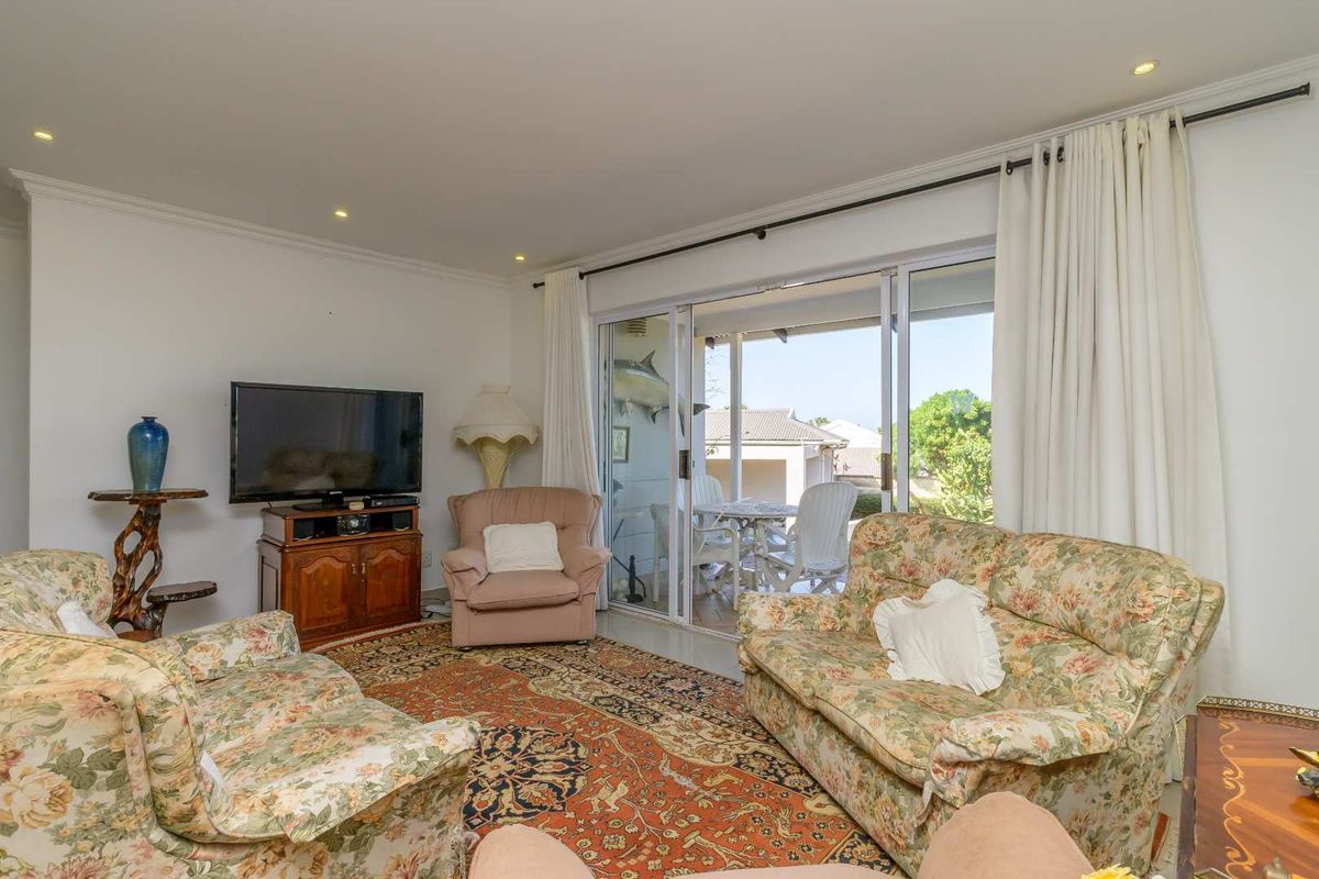 A comfortable living room featuring recessed downlighting and large sliding glass doors that provide direct access to an outdoor patio area.