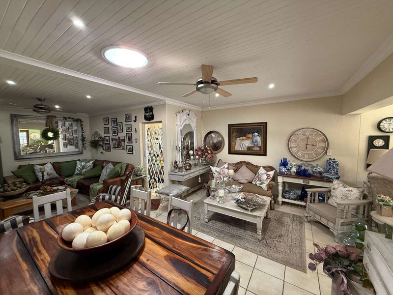 Spacious open-plan living and dining area featuring tiled floors, a tongue and groove ceiling with recessed lighting, and a ceiling fan.