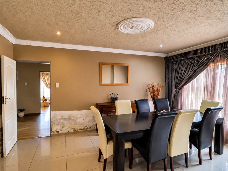Dining room featuring tiled floors, decorative ceiling rose, and coving, currently showing significant signs of wall moisture damage requiring repair.