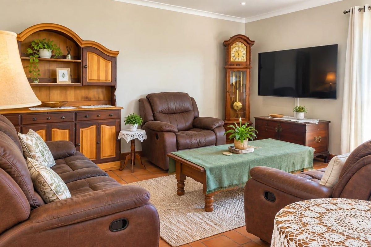A comfortable living room featuring terracotta floor tiles, neutral wall finishes, and recessed lighting, providing a warm and inviting atmosphere.