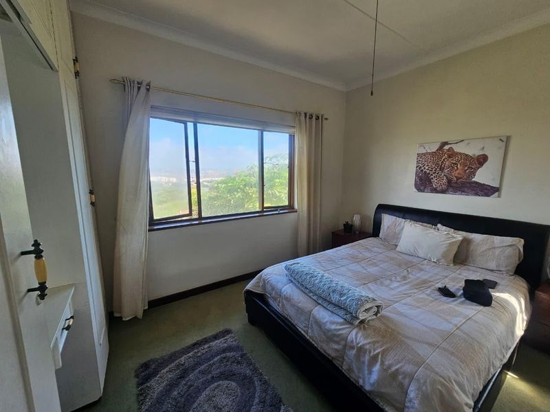 A bedroom featuring built-in wardrobe storage, coving, and a window with natural light and exterior views.