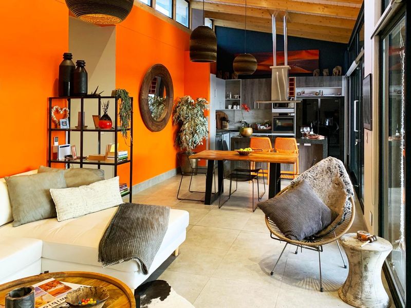 Spacious open-plan living and kitchen area featuring high ceilings with exposed timber beams, modern cabinetry, and large sliding doors leading to outdoor space.