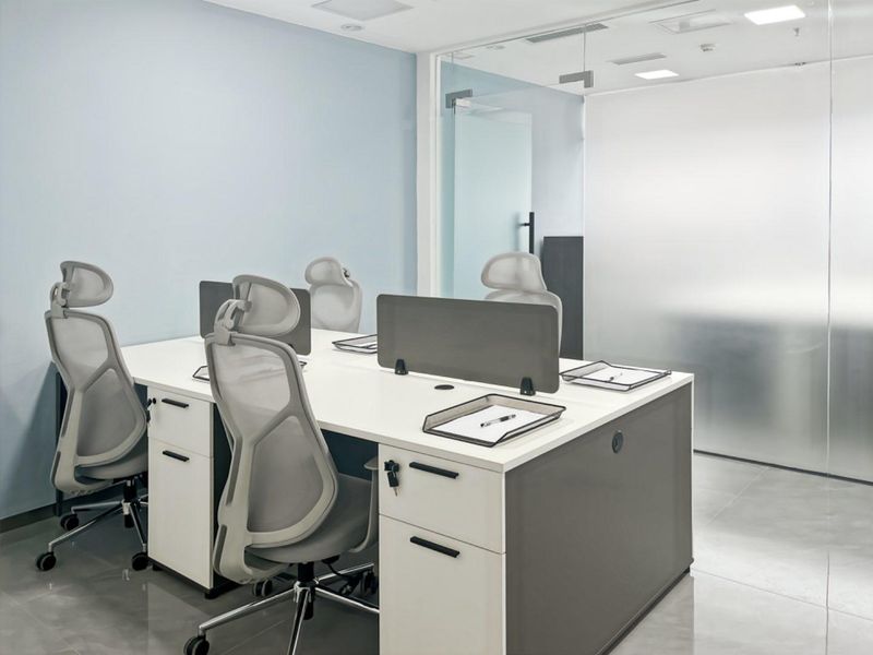 Modern office space featuring clean lines, recessed ceiling lighting, and a contemporary glass partition wall, creating a professional and bright work environment.
