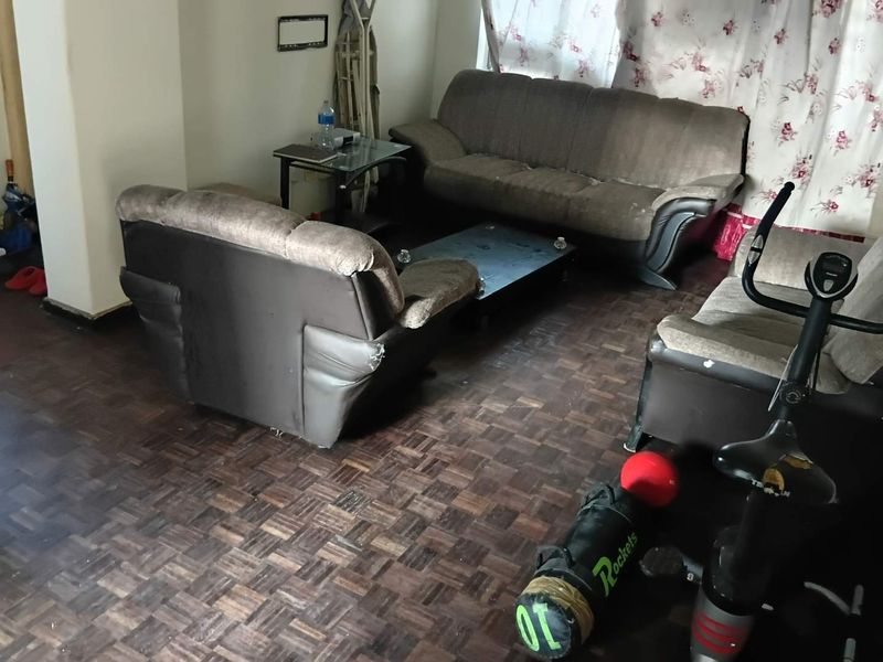 A living room area featuring dark parquet flooring, providing a foundation for potential renovation and interior design updates.