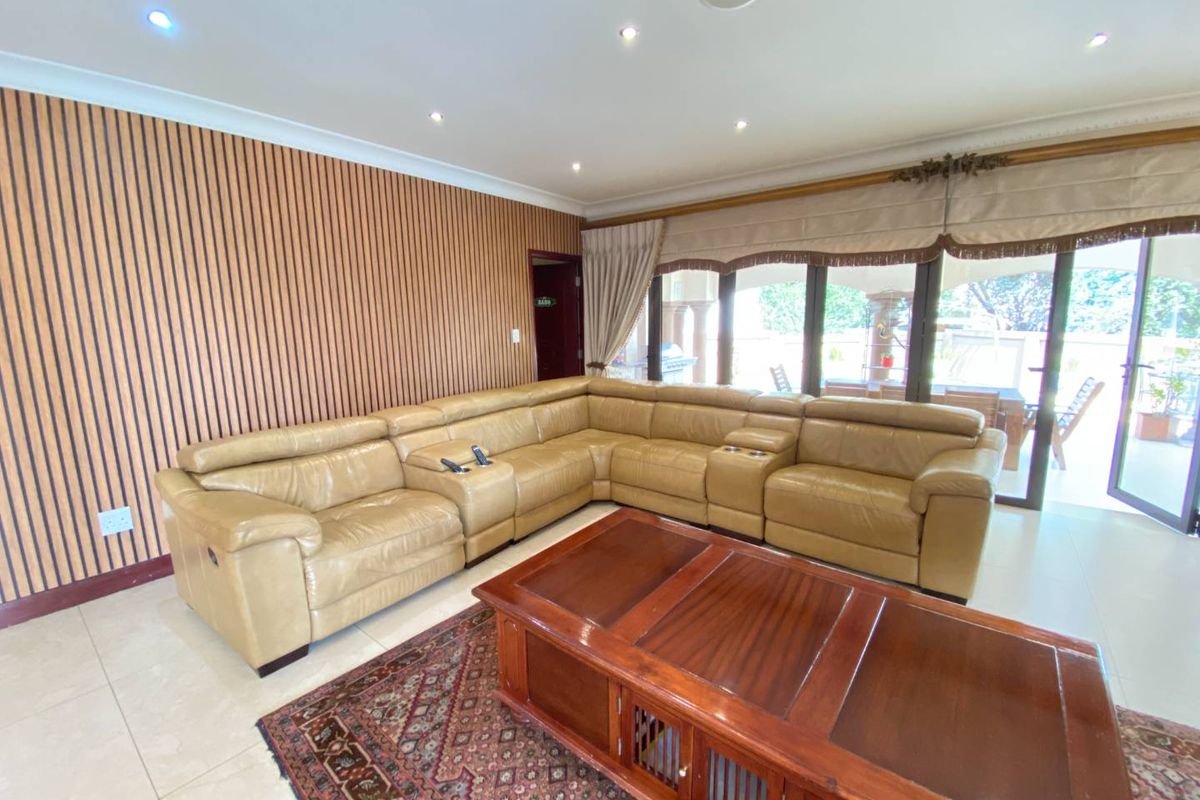 Spacious living room featuring modern slatted timber wall paneling, tiled flooring, and large sliding glass doors providing access to the outdoor area.