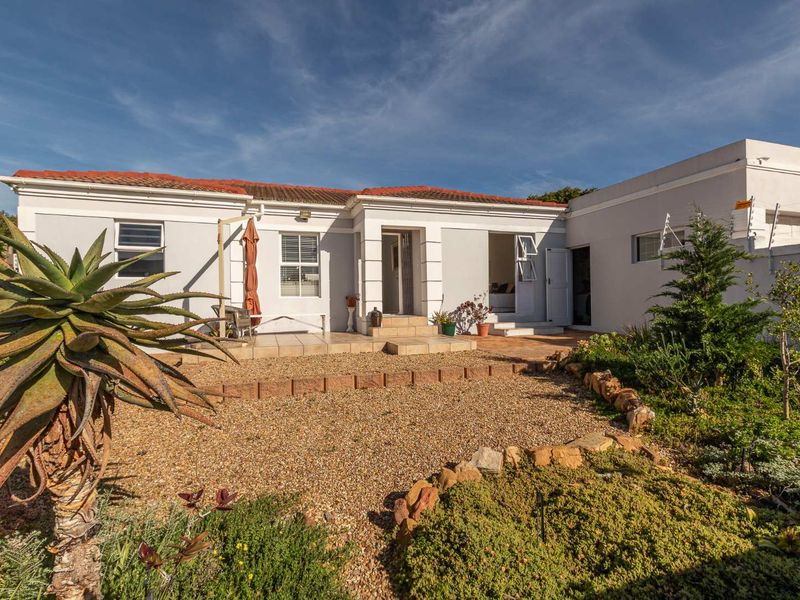 Rear view of the property featuring a tiled patio area, gravel garden, and secure perimeter with electric fencing.