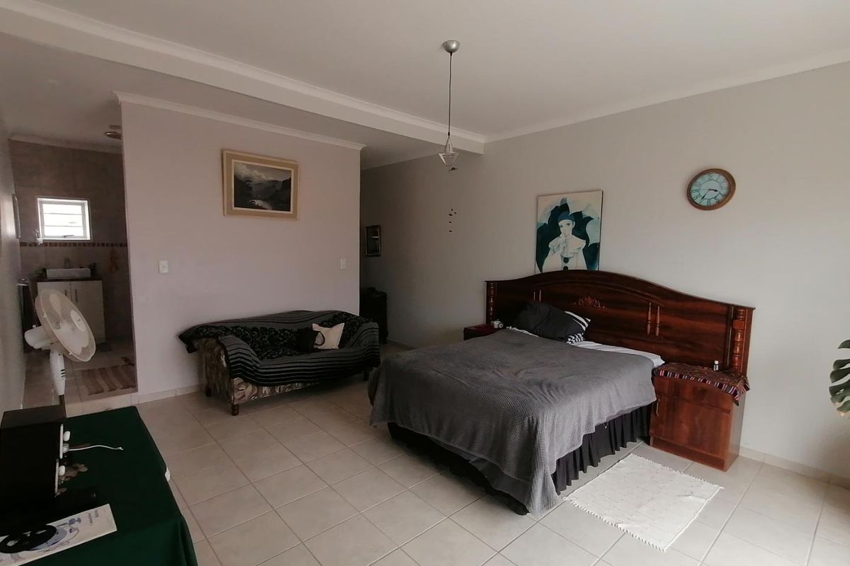 Spacious bedroom featuring tiled flooring, recessed ceiling detail, and an adjoining en-suite bathroom area.