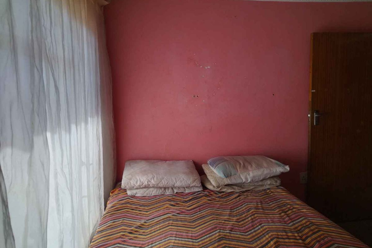 A bedroom featuring decorative ceiling cornicing, currently requiring wall surface repairs and repainting to improve the overall aesthetic.