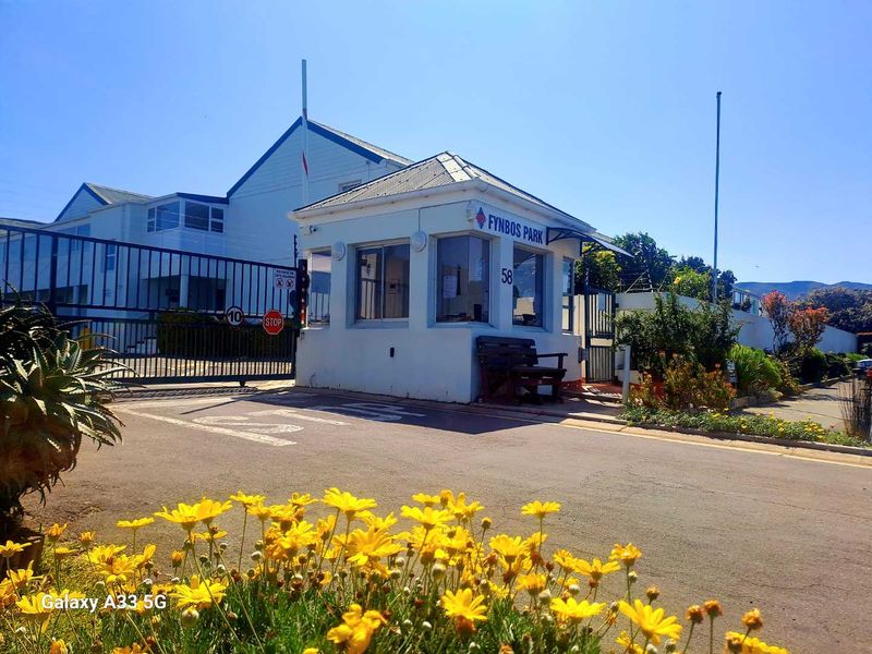 Front entrance view of Fynbos Park featuring a security gate, guard house, and paved driveway access.