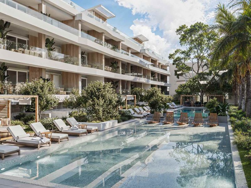A modern apartment complex featuring a large swimming pool, landscaped gardens, and private balconies with glass railings.