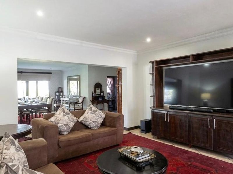 Spacious open-plan living area featuring built-in cabinetry, recessed lighting, and tiled flooring, with a seamless transition into the adjacent dining space.