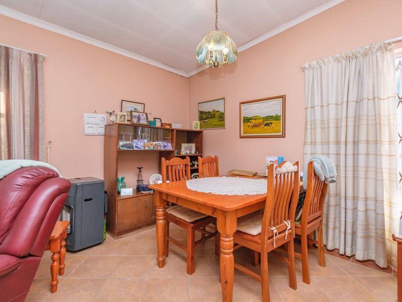 A dining room featuring tiled flooring and a central ceiling light fixture, providing a functional space for family meals.