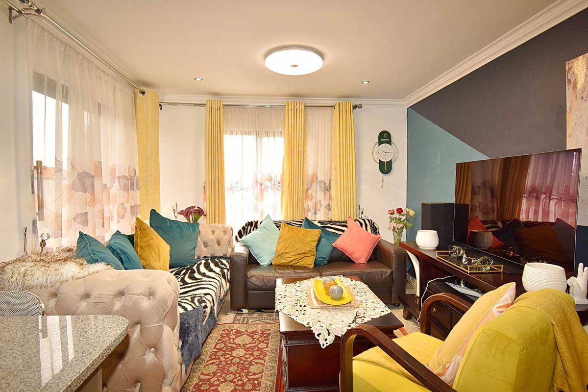 A cozy living room featuring crown molding, recessed lighting, and large windows that allow for ample natural light.