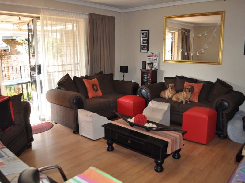 A comfortable living room featuring laminate flooring and a sliding glass door providing access to the outdoor area.