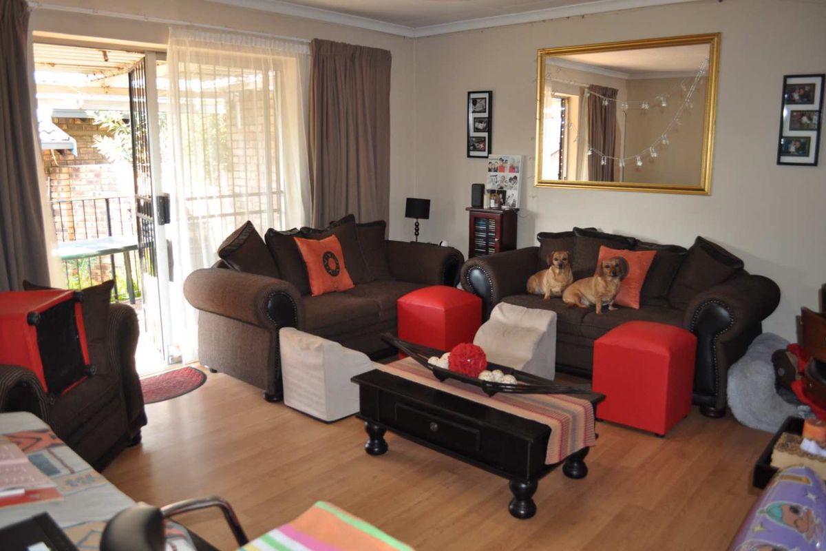 A comfortable living room featuring laminate flooring and a sliding glass door providing access to the outdoor area.