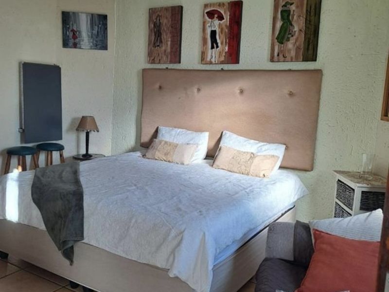 A bedroom featuring tiled flooring and a neutral wall finish, providing a functional space for rest.