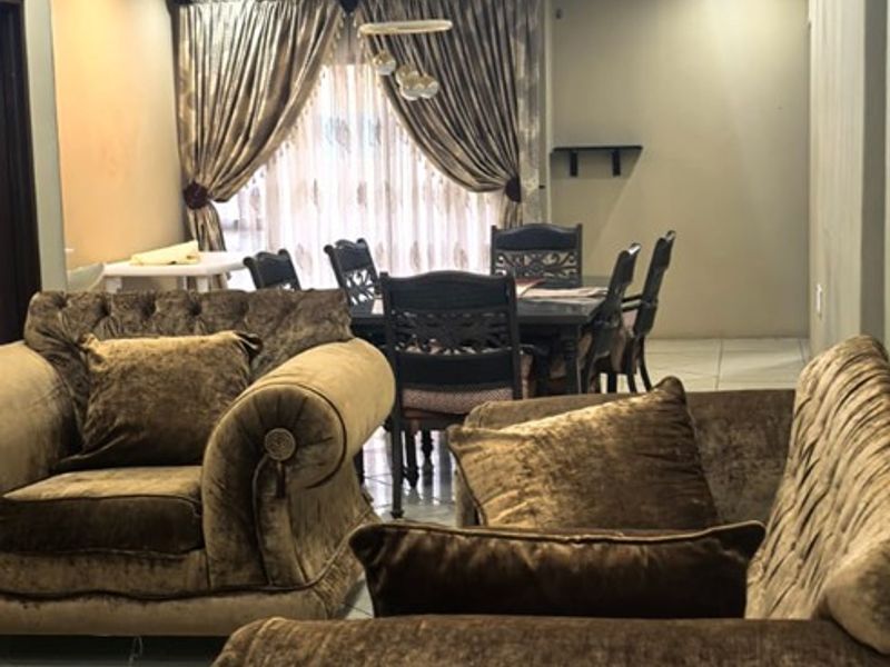 Open plan living and dining area featuring tiled flooring, a dropped ceiling with recessed lighting, and neutral wall finishes.
