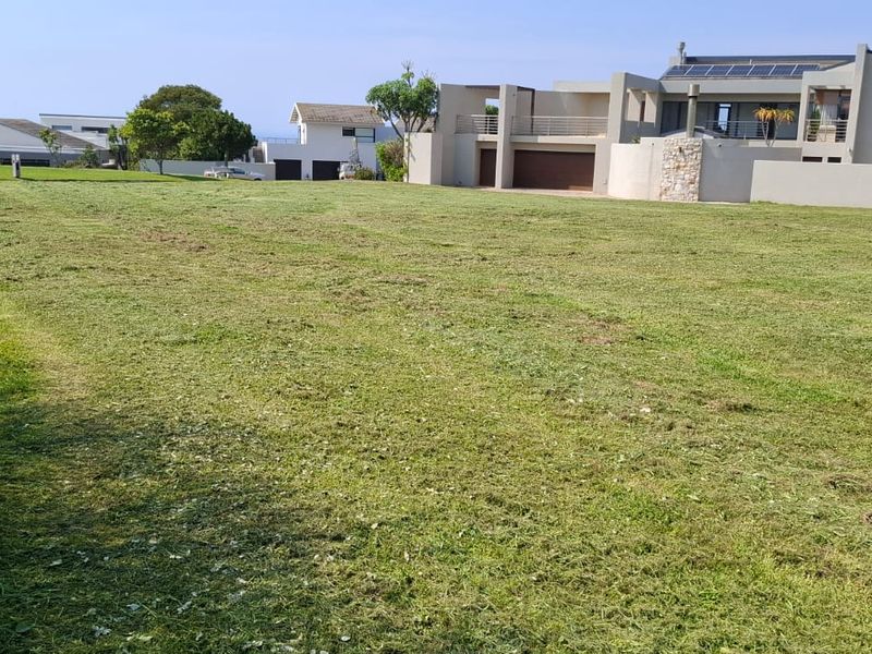 A spacious, cleared residential plot of land with established boundary fencing, offering a clear view of neighboring properties.