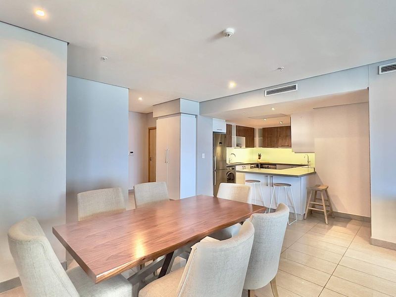 Modern open-plan living and dining area featuring tiled floors, recessed lighting, ducted air conditioning, and a well-appointed kitchen with built-in cabinetry.