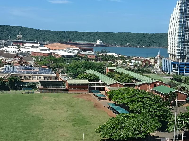 Elevated panoramic view overlooking the surrounding urban landscape, green spaces, and distant harbor area.