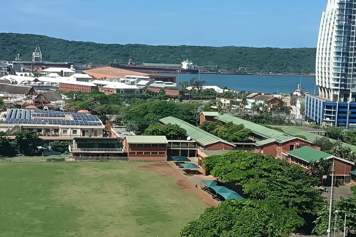Elevated panoramic view overlooking the surrounding urban landscape, green spaces, and distant harbor area.