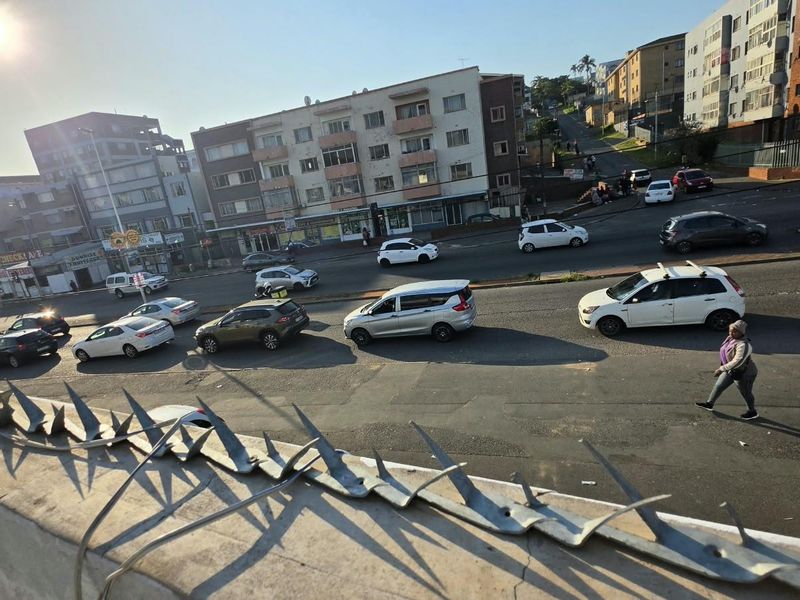An elevated street view showing a busy urban intersection with surrounding apartment buildings and traffic.