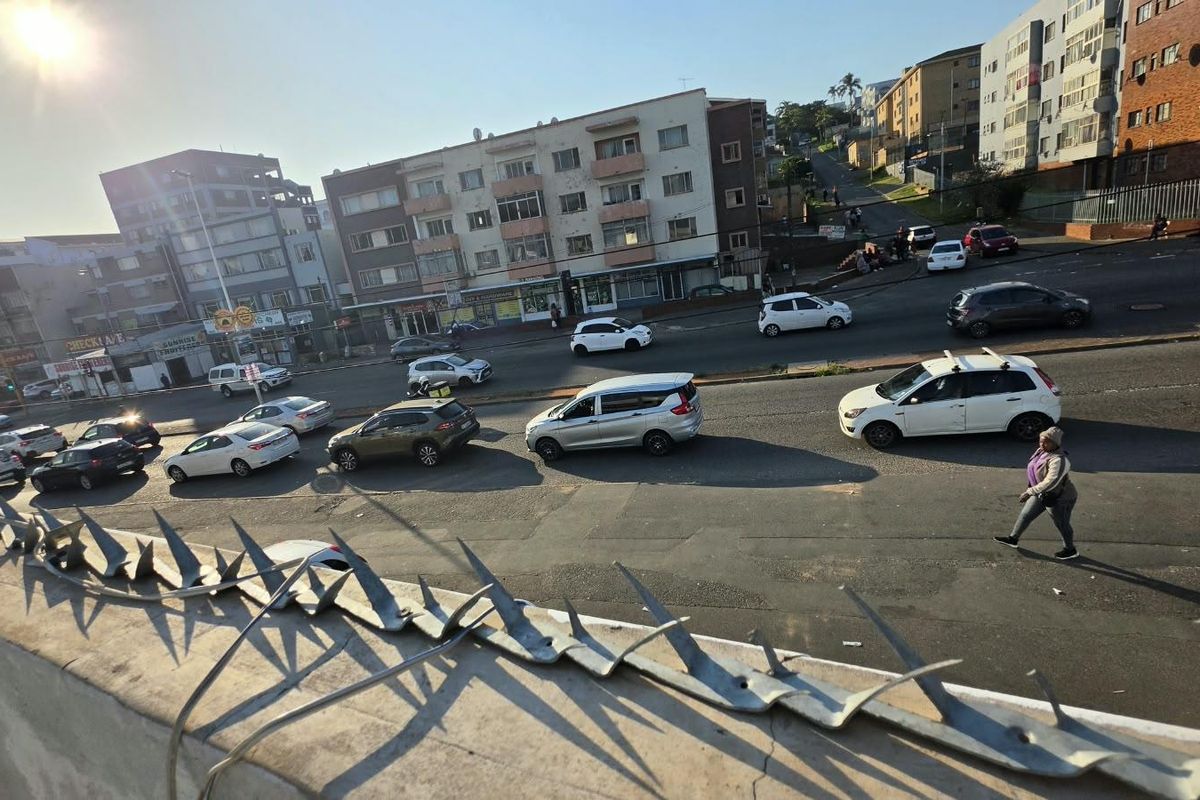 An elevated street view showing a busy urban intersection with surrounding apartment buildings and traffic.