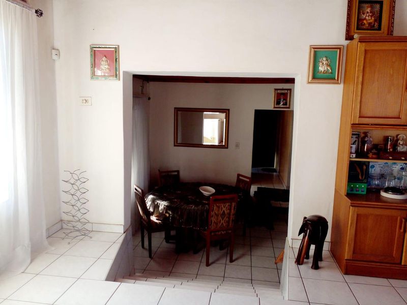 A dining area featuring tiled flooring and a stepped transition, with built-in cabinetry providing storage space.
