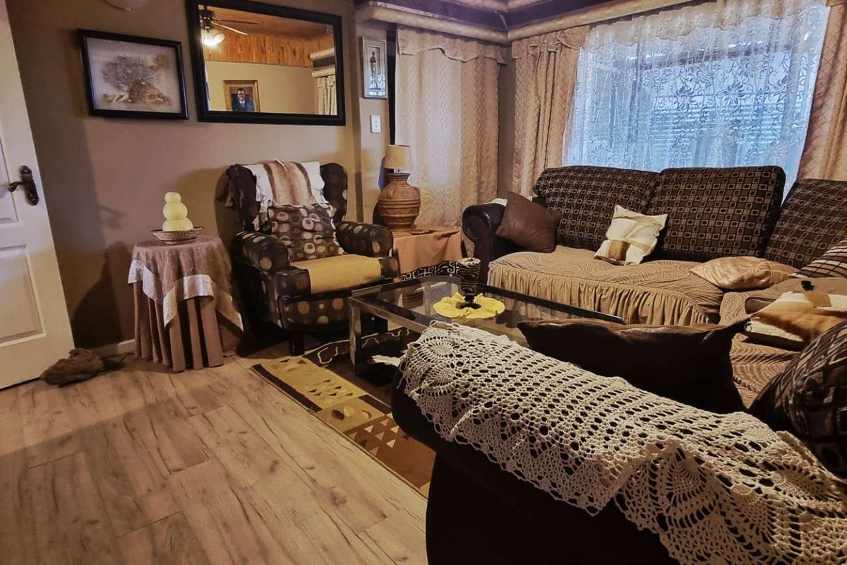A cozy living room featuring laminate flooring and a panelled ceiling, offering a comfortable and traditional living space.