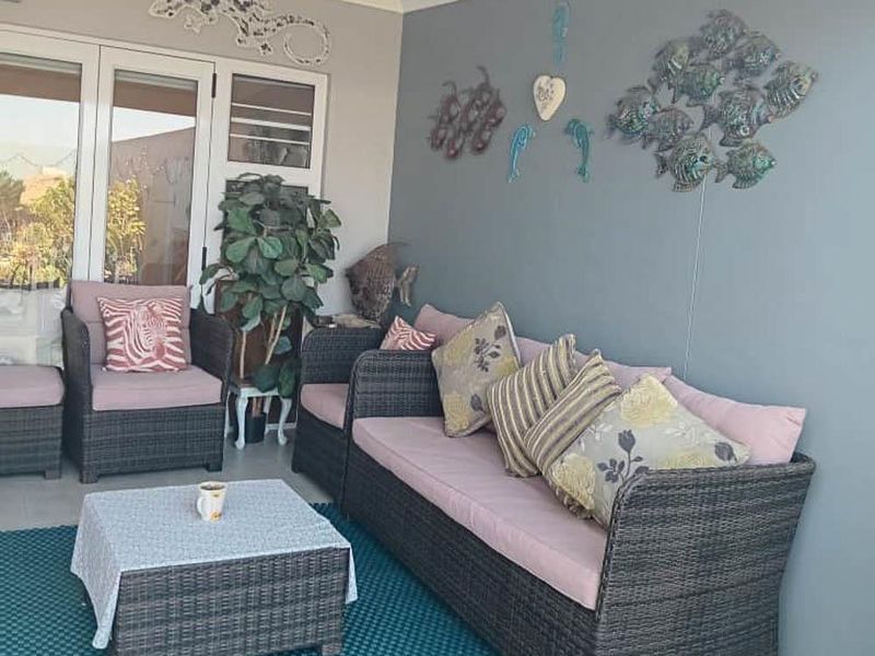 A covered patio area featuring tiled flooring and sliding glass doors, providing a comfortable transition to the outdoor space.