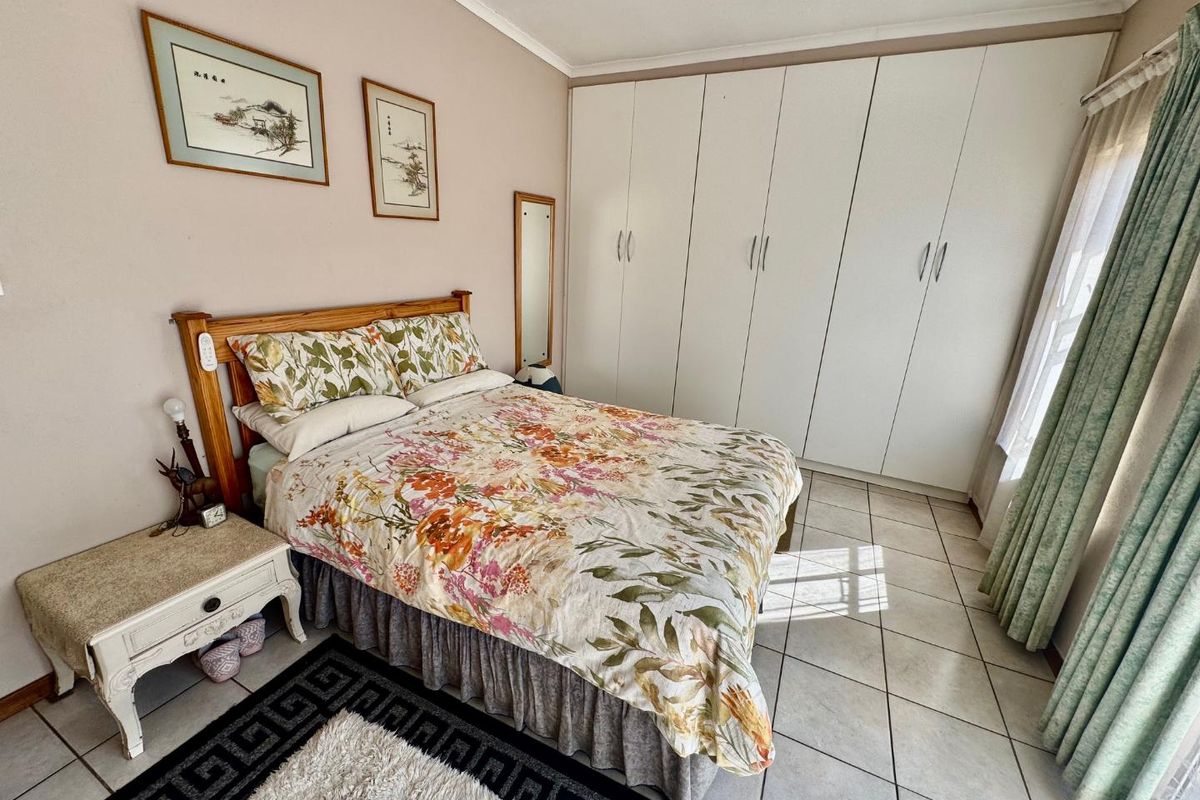 A bedroom featuring built-in floor-to-ceiling wardrobes and tiled flooring, offering functional storage space.