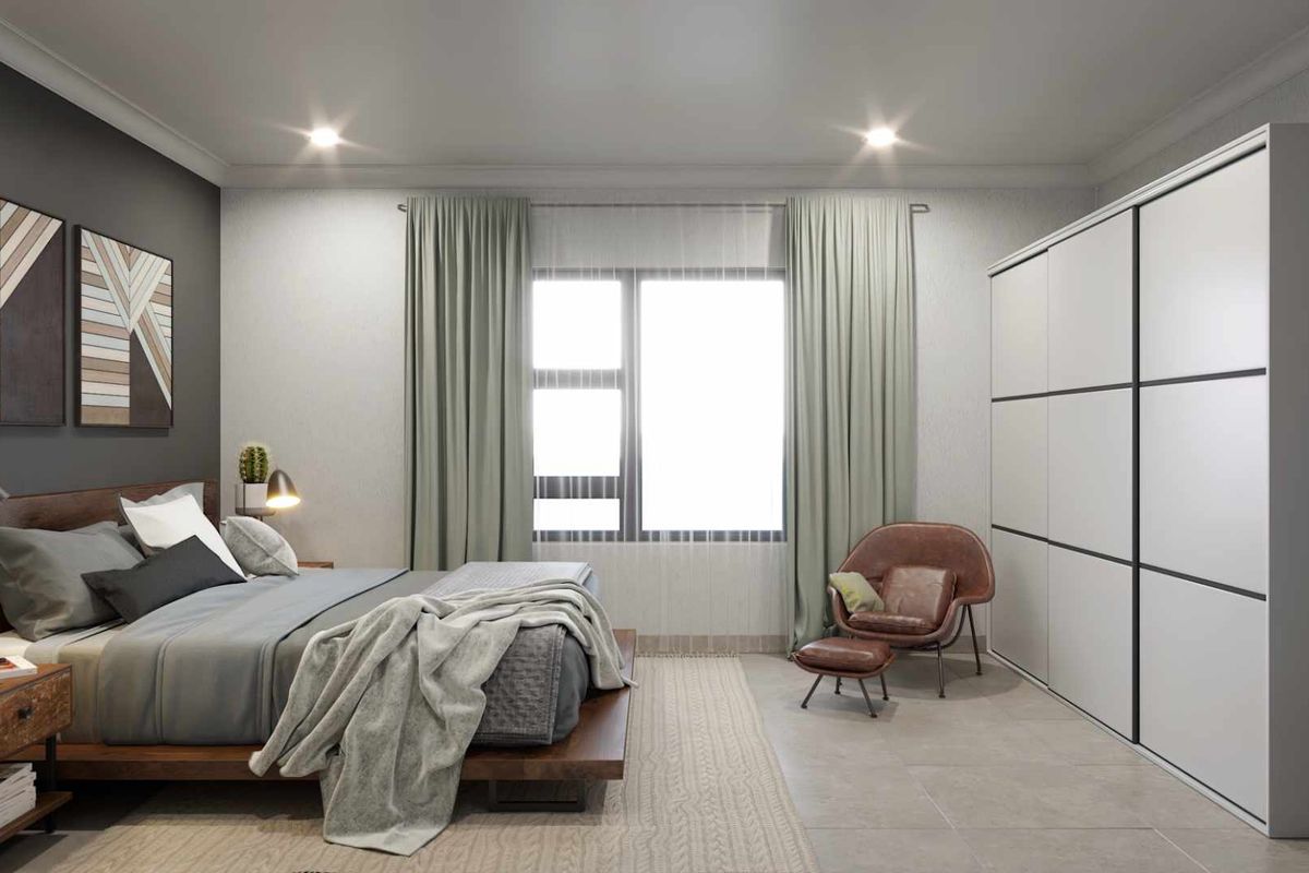 A modern, well-appointed bedroom featuring built-in floor-to-ceiling wardrobes, tiled flooring, and recessed ceiling lighting.