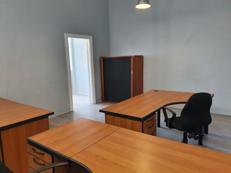 A functional office space featuring laminate flooring and neutral wall finishes, providing a clean and professional environment for work.