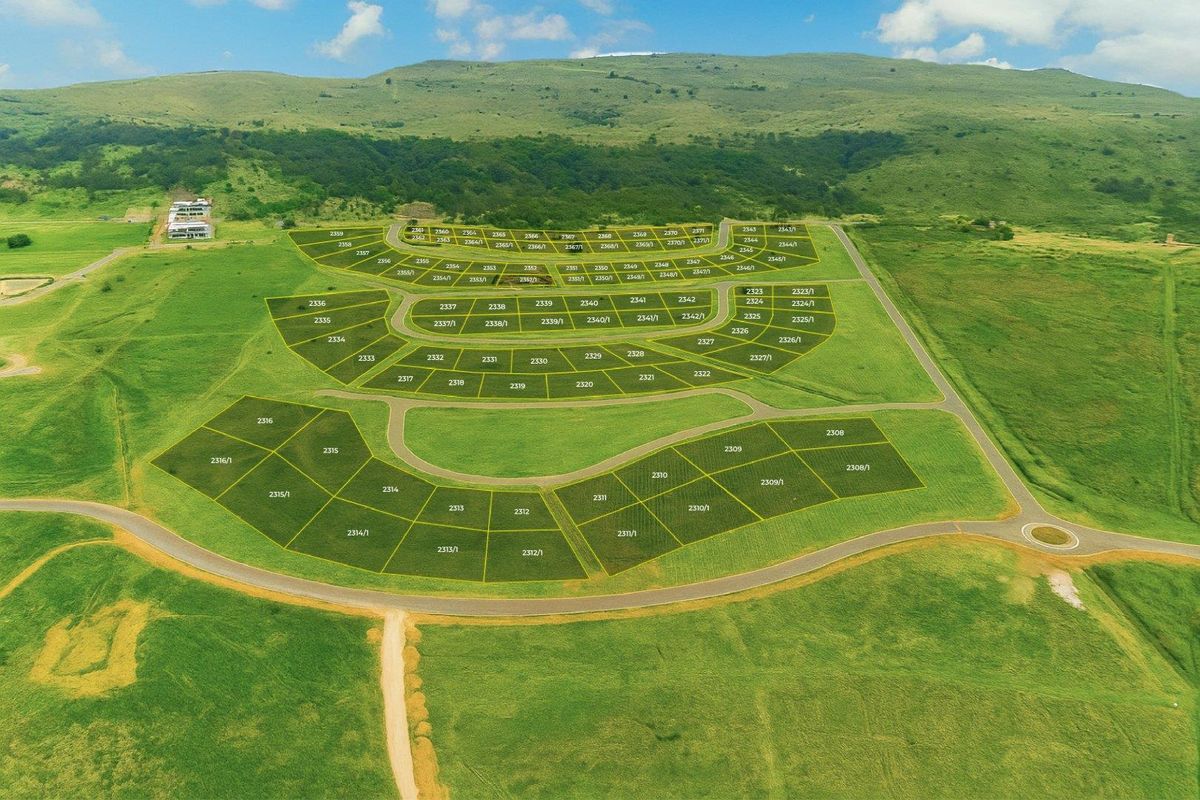 Aerial view of a land development site showing subdivided plots and road infrastructure layout.