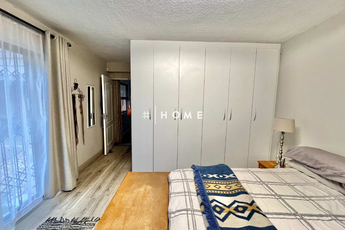 A well-lit bedroom featuring built-in floor-to-ceiling wardrobes and sliding door access to an outdoor area.