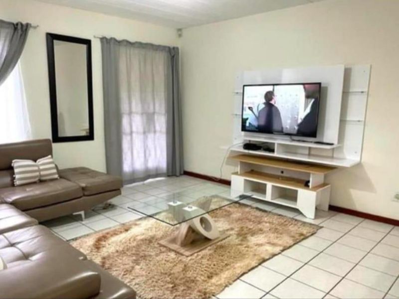A living room featuring tiled flooring and a built-in media console unit, providing a functional space for relaxation and entertainment.