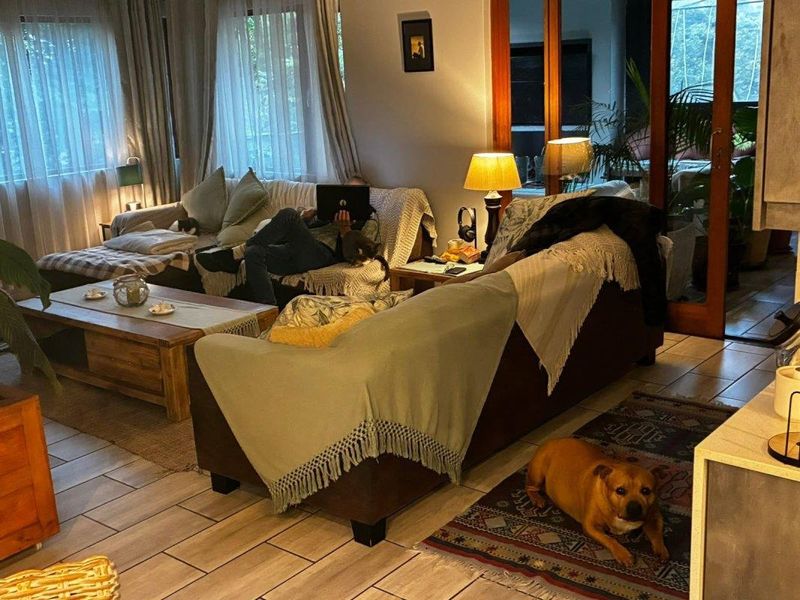 A cozy living room featuring tiled flooring and large sliding glass doors that provide natural light and access to the outdoor area.