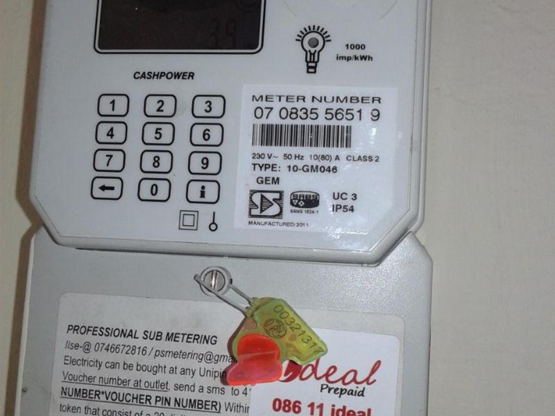 A wall-mounted Landis+Gyr prepaid electricity meter unit with sub-metering contact information displayed.