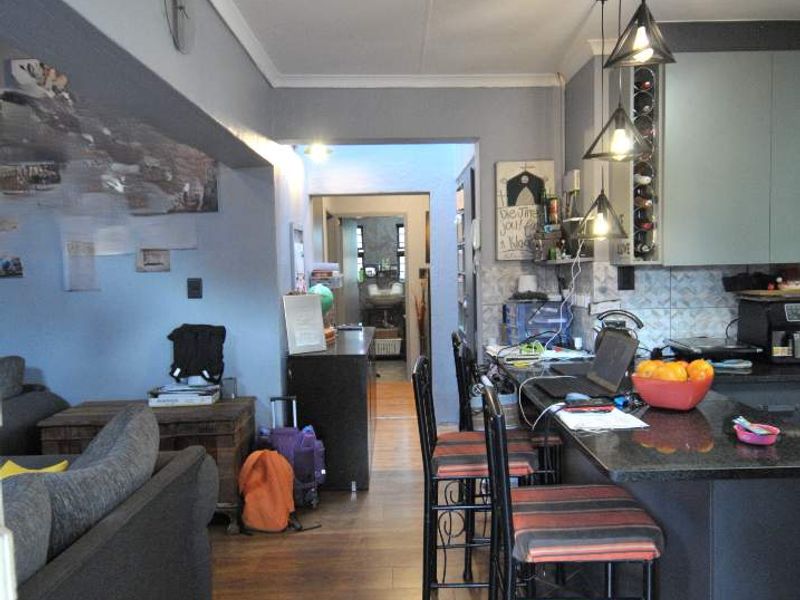 Open plan living and kitchen area featuring granite countertops, built-in cabinetry, and laminate flooring, creating a functional and connected living space.