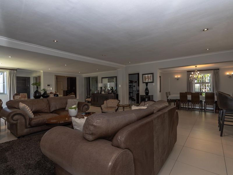 Spacious open-plan living and dining area featuring neutral tiled flooring, recessed downlighting, and seamless flow between the lounge and dining spaces.