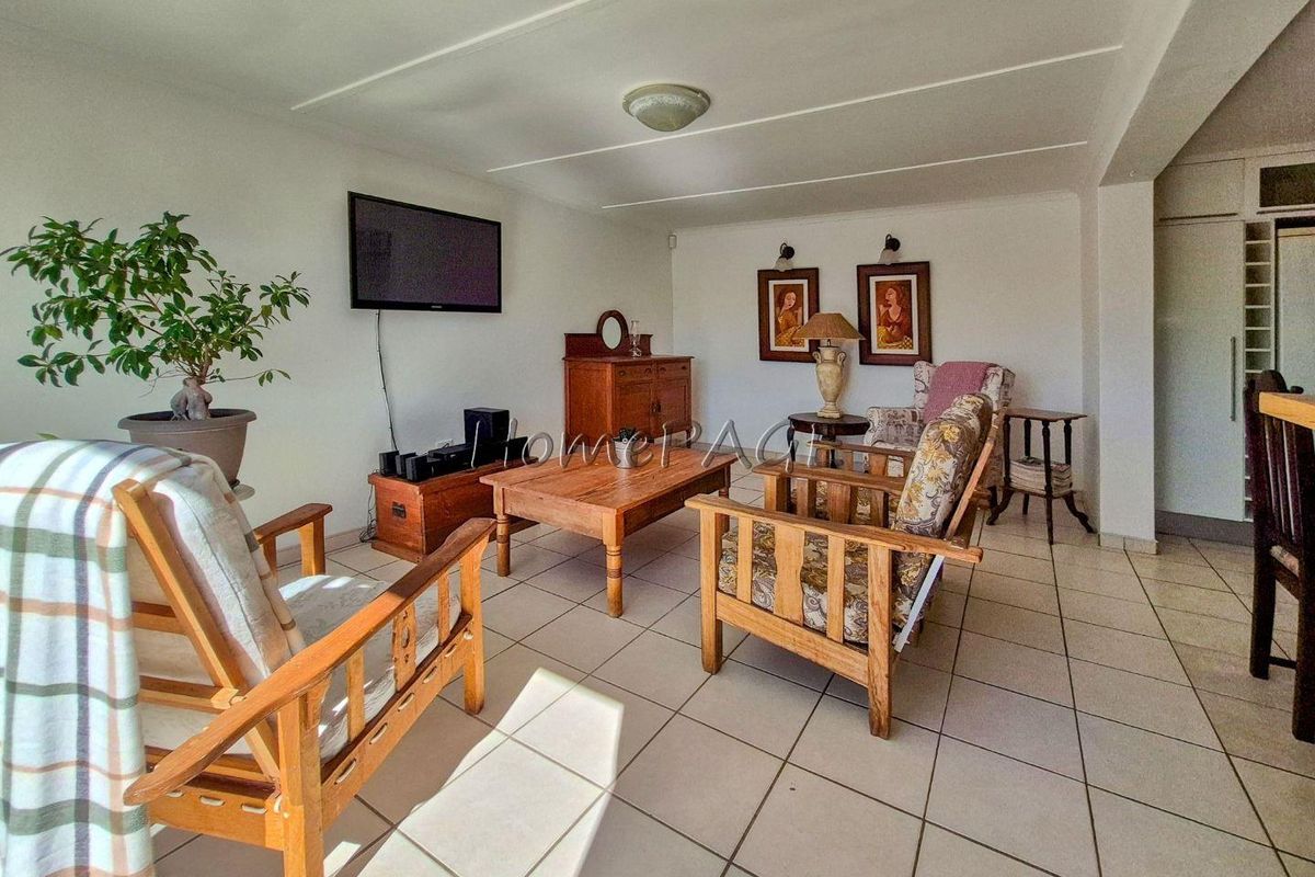 A spacious living area featuring neutral floor tiles and a clean, functional layout, providing a comfortable space for relaxation and daily living.