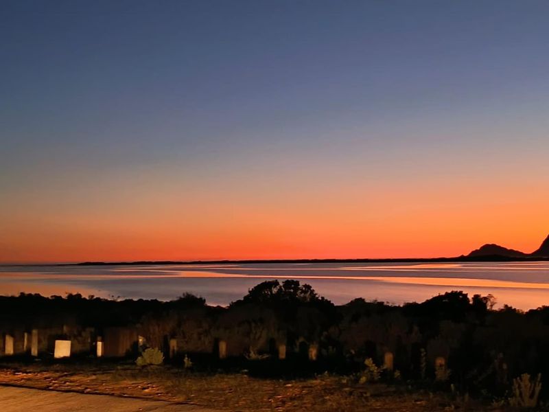 A scenic sunset view overlooking the water and distant landscape, showcasing the natural beauty and tranquil setting of the residential land.